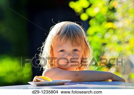 boy with long blond hair eating in the garden View Large Photo Image Picture - boy with long blond hair eating in the garden. Fotosearch