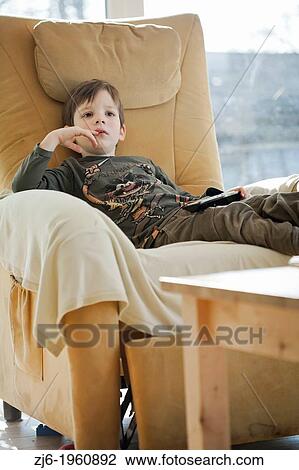 Boy with remote control watching TV. View Large Photo Image Stock Image - Boy with remote control watching TV.. Fotosearch
