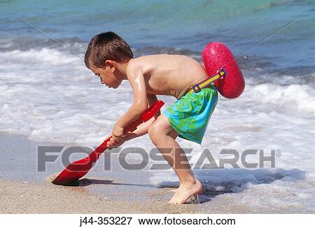 Boy with shovel at the beach View Large Photo Image Stock Photo - Boy with shovel at the beach. Fotosearch