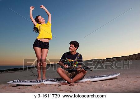 Stock Photo - boyfriends singing and dancing with guitar. Fotosearch