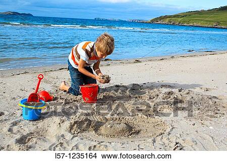 boyl playing on sandy beach, Sutherland, Scotland View Large Photo Image Picture - boyl playing on sandy beach, Sutherland, Scotland. Fotosearch