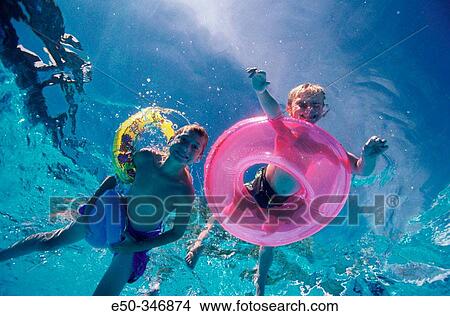 Boys aged 5 and 12 in a swimming-pool. View Large Photo Image Picture - Boys aged 5 and 12 in a swimming-pool.. Fotosearch