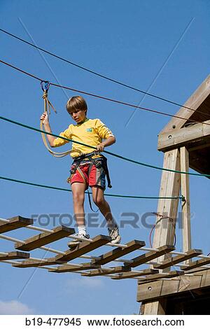 Boys crossing hanging footbridge in camp View Large Photo Image Stock Photography - Boys crossing hanging footbridge in camp. Fotosearch