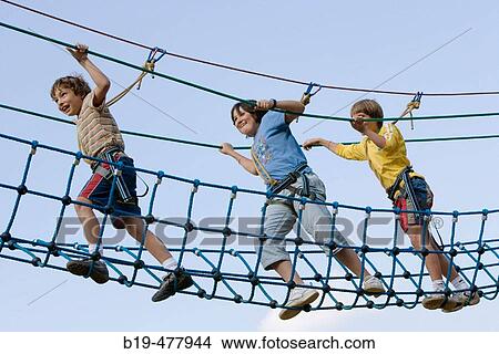 Boys crossing rope bridge in camp View Large Photo Image Picture - Boys crossing rope bridge in camp. Fotosearch