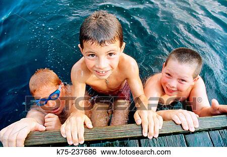 Boys enjoying themselves at a lake View Large Photo Image Stock Photograph - Boys enjoying themselves at a lake. Fotosearch