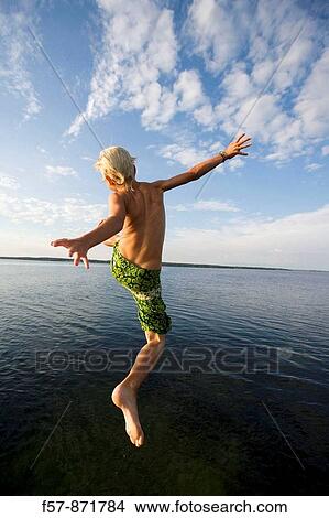 Boys leaping off a pier in Denmark View Large Photo Image Picture - Boys leaping off a pier in Denmark. Fotosearch