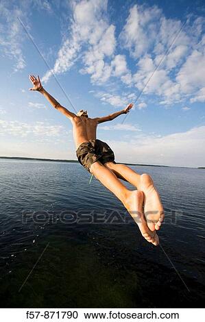 Boys leaping off a pier in Denmark View Large Photo Image Stock Image - Boys leaping off a pier in Denmark. Fotosearch