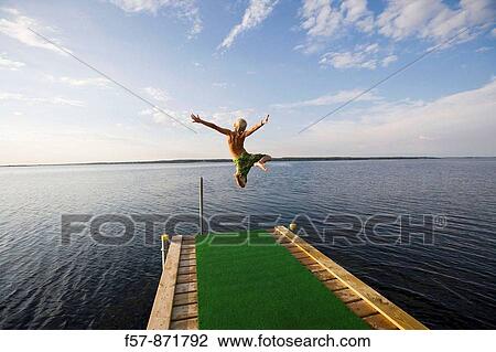 Boys leaping off a pier in Denmark View Large Photo Image Stock Image - Boys leaping off a pier in Denmark. Fotosearch