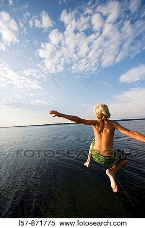 Boys leaping off a pier in Denmark View Large Photo Image Stock Photography - Boys leaping off a pier in Denmark. Fotosearch