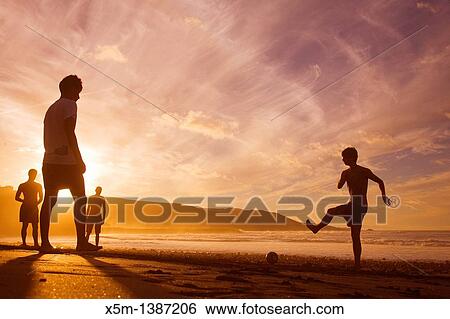 Boys playing football on the beach at sunset Las Canteras beach in Las Palmas de Gran Canaria View Large Photo Image Stock Photograph - Boys playing football on the beach at sunset Las Canteras beach in Las Palmas de Gran Canaria. Fotosearch
