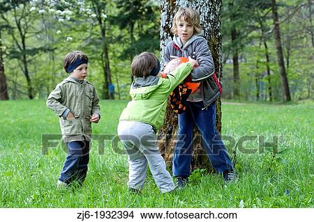 Picture - Boys playing outdoor with ball. Older boy took the ball to the younger one causing conflict.. Fotosearch