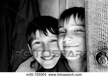 Picture - Boys smiling in doorway at home -black and white film-. Fotosearch