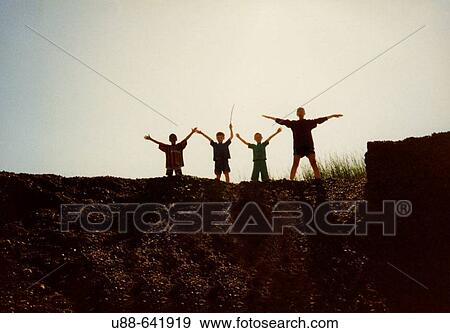 Stock Photo - Boys standing on cliff.. Fotosearch