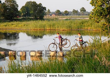 Boys with bicycles crossing a lake, Netherlands View Large Photo Image Stock Image - Boys with bicycles crossing a lake, Netherlands. Fotosearch