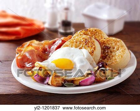 Breakfast - crumpets, sauteed potatoes, fried egg and bacon View Large Photo Image Stock Photo - Breakfast - crumpets, sauteed potatoes, fried egg and bacon. Fotosearch