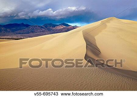 Stock Image - Breaking thunderstorm over Mesquite Dunes, Death Valley National Park, California. Fotosearch