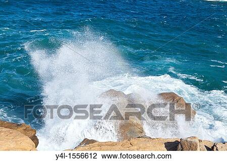 Stock Image - Breaking Wave on Rock, Giglio Island, Italy. Fotosearch