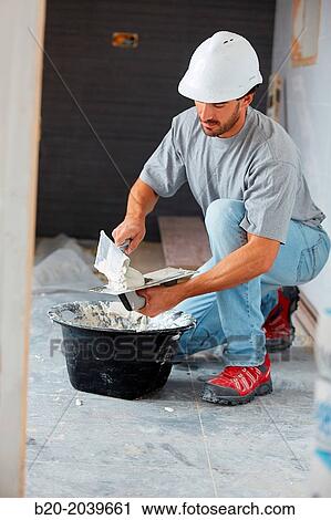 Bricklayer applying tile adhesive for tiling. Construction of residential building. Donostia. San Sebastian. Gipuzkoa. Basque Country. Spain. View Large Photo Image Stock Image - Bricklayer applying tile adhesive for tiling. Construction of residential building. Donostia. San Sebastian. Gipuzkoa. Basque Country. Spain.. Fotosearch