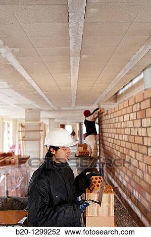Bricklayer, bricking up a partition wall, new homes under construction, construction site View Large Photo Image Stock Image - Bricklayer, bricking up a partition wall, new homes under construction, construction site. Fotosearch