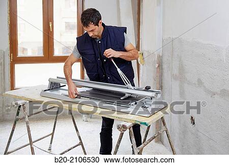 Bricklayer cutting tile. Manual tile cutter. Kitchen renovation work. Construction Industry. View Large Photo Image Stock Image - Bricklayer cutting tile. Manual tile cutter. Kitchen renovation work. Construction Industry.. Fotosearch
