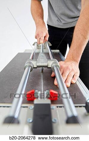 Bricklayer cutting tile. Manual tile cutter. Construction Industry. View Large Photo Image Stock Photo - Bricklayer cutting tile. Manual tile cutter. Construction Industry.. Fotosearch