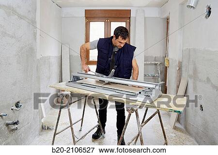 Bricklayer cutting tile. Manual tile cutter. Kitchen renovation work. Construction Industry. View Large Photo Image Stock Photo - Bricklayer cutting tile. Manual tile cutter. Kitchen renovation work. Construction Industry.. Fotosearch
