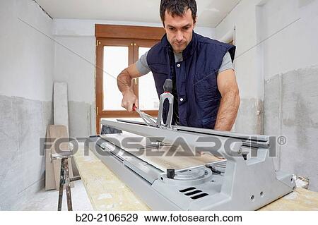 Bricklayer cutting tile. Manual tile cutter. Kitchen renovation work. Construction Industry. View Large Photo Image Stock Photo - Bricklayer cutting tile. Manual tile cutter. Kitchen renovation work. Construction Industry.. Fotosearch