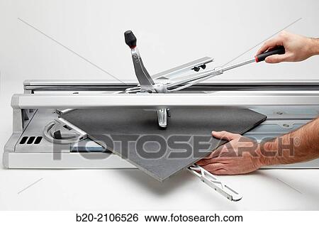 Bricklayer cutting tile. Manual tile cutter. Construction Industry. View Large Photo Image Stock Photograph - Bricklayer cutting tile. Manual tile cutter. Construction Industry.. Fotosearch