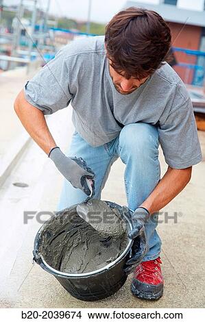 Bricklayer making cement mortar. Construction of residential building. Donostia. San Sebastian. Gipuzkoa. Basque Country. Spain. View Large Photo Image Picture - Bricklayer making cement mortar. Construction of residential building. Donostia. San Sebastian. Gipuzkoa. Basque Country. Spain.. Fotosearch