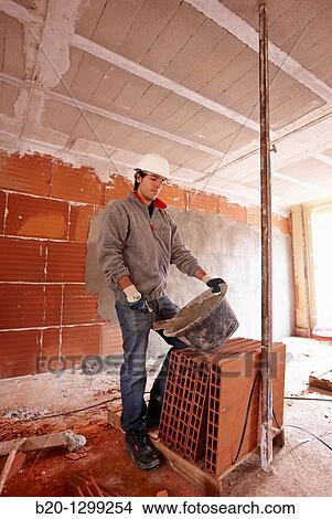 Bricklayer with trowel, bricks, new homes under construction, construction site View Large Photo Image Picture - Bricklayer with trowel, bricks, new homes under construction, construction site. Fotosearch