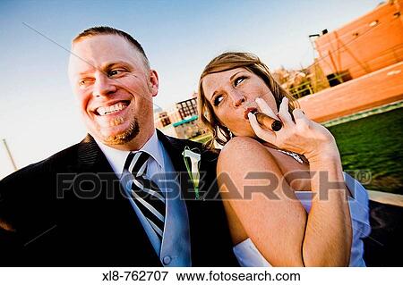Bridal couple, bride smoking grooms cigar View Large Photo Image Stock Photo - Bridal couple, bride smoking grooms cigar. Fotosearch