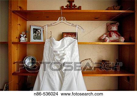 Bridal gown hanging on shelves View Large Photo Image Picture - Bridal gown hanging on shelves. Fotosearch