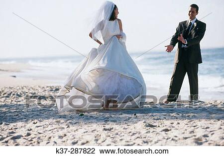Stock Image - Bride and groom dancing on beach. Fotosearch