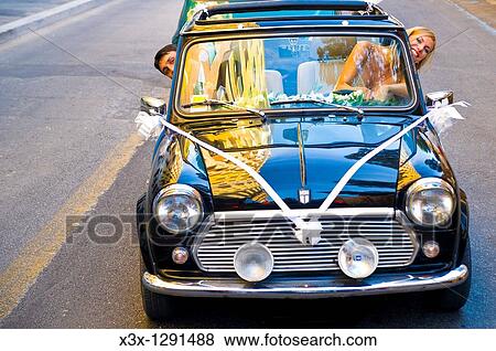 Bride and groom driving in a mini cooper View Large Photo Image Stock Photo - Bride and groom driving in a mini cooper. Fotosearch