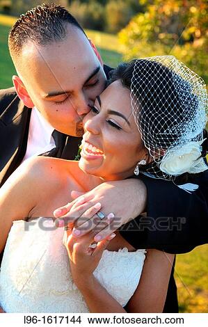 bride and groom embracing kissing smiling happy on wedding day View Large Photo Image Picture - bride and groom embracing kissing smiling happy on wedding day. Fotosearch