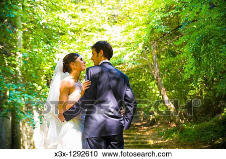 Stock Image - Bride and groom in love in a park. Fotosearch