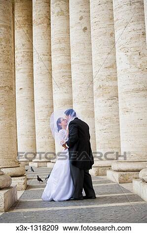 Bride and groom kissing among the colonnade of Saint Peter's square Vatican Rome Italy View Large Photo Image Stock Photo - Bride and groom kissing among the colonnade of Saint Peter's square Vatican Rome Italy. Fotosearch