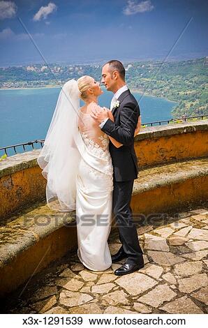 Bride and groom kissing in front of a Lake View Large Photo Image Stock Photo - Bride and groom kissing in front of a Lake. Fotosearch