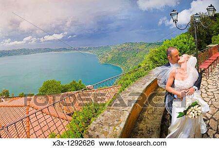 Bride and groom kissing in front of a Lake View Large Photo Image Stock Photograph - Bride and groom kissing in front of a Lake. Fotosearch