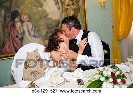 Bride and groom kissing ina restaurant View Large Photo Image Stock Photo - Bride and groom kissing ina restaurant. Fotosearch