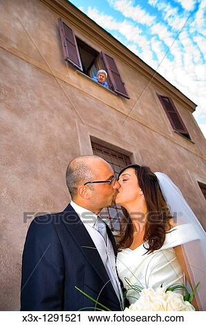 Bride and groom kissing with an old lady looking from above View Large Photo Image Stock Image - Bride and groom kissing with an old lady looking from above. Fotosearch