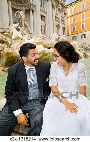 Bride and groom laughing in front of Trevi Fountain, Rome, Italy View Large Photo Image Picture - Bride and groom laughing in front of Trevi Fountain, Rome, Italy. Fotosearch