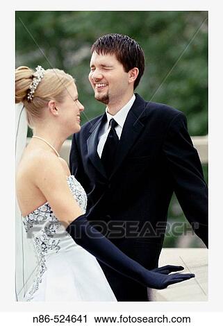 Stock Image - Bride and groom laughing outdoors. Fotosearch