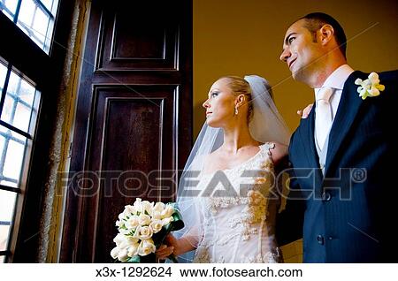 Bride and groom looking out the window View Large Photo Image Picture - Bride and groom looking out the window. Fotosearch