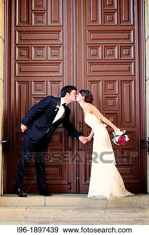 bride and groom on the front steps of the courthouse doors capturing a quick kiss after the wedding View Large Photo Image Stock Photo - bride and groom on the front steps of the courthouse doors capturing a quick kiss after the wedding. Fotosearch