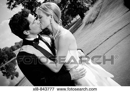 Stock Photo - bride and groom portrait, kissing, outside, just married. Fotosearch