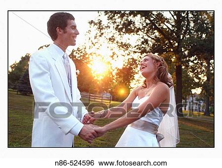 Bride and groom posed together outside View Large Photo Image Stock Photograph - Bride and groom posed together outside. Fotosearch