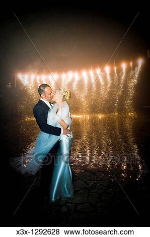 Bride and groom posing in front of fireworks display View Large Photo Image Stock Photo - Bride and groom posing in front of fireworks display. Fotosearch