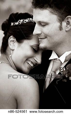 Stock Image - Bride and groom smiling together, intimate. Fotosearch