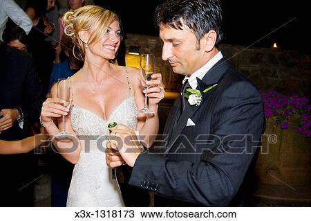 Stock Image - Bride and groom toasting at the wedding. Fotosearch